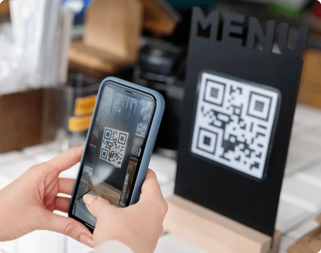 Klient skanuje QR menu restauracji telefonem